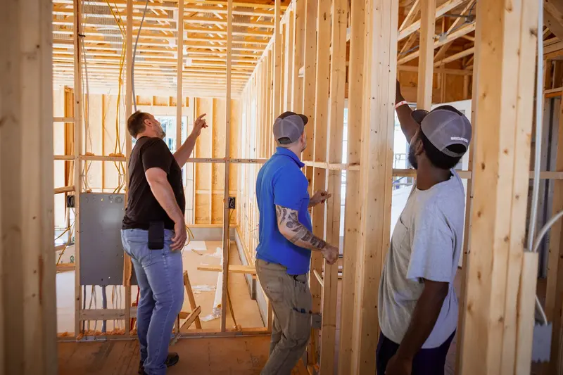 The Secur-Tek crew walking a framed house on a pre-wire, pointing out the runs.