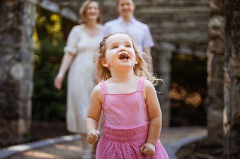 Little girl laughing at a park family session, photographed by GKeyPhoto